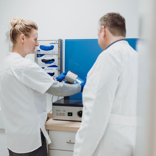 Oxidationstherapie bei NEURO Südwestfalen Ein Arzt und eine medizinische Fachangestellte in weißen Kitteln stehen vor einer Maschine zur Oxidationstherapie
