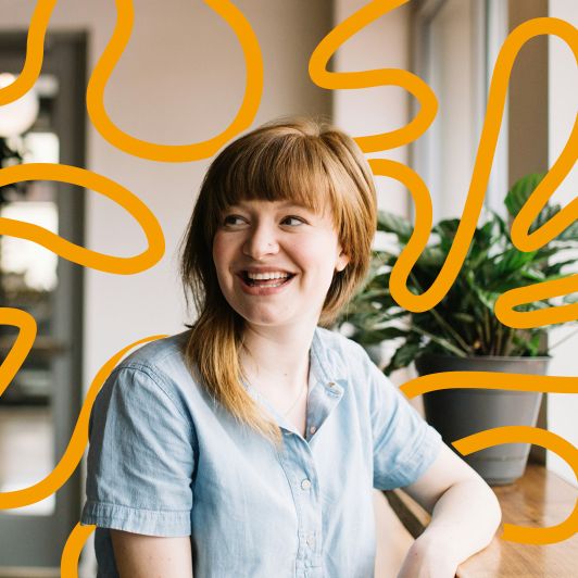 Karriere bei NEURO Südwestfalen | Fachärzte, medizinische Fachangestellte Auf dem Bild sieht man eine junge Frau mit rötlichen Haaren und Pony, die fröhlich lächelt. Im Hintergrund sieht man das orangefarbene Design-Element von NEURO Südwestfalen, welches einen Querschnitt durch Gehirnwindungen darstellt.